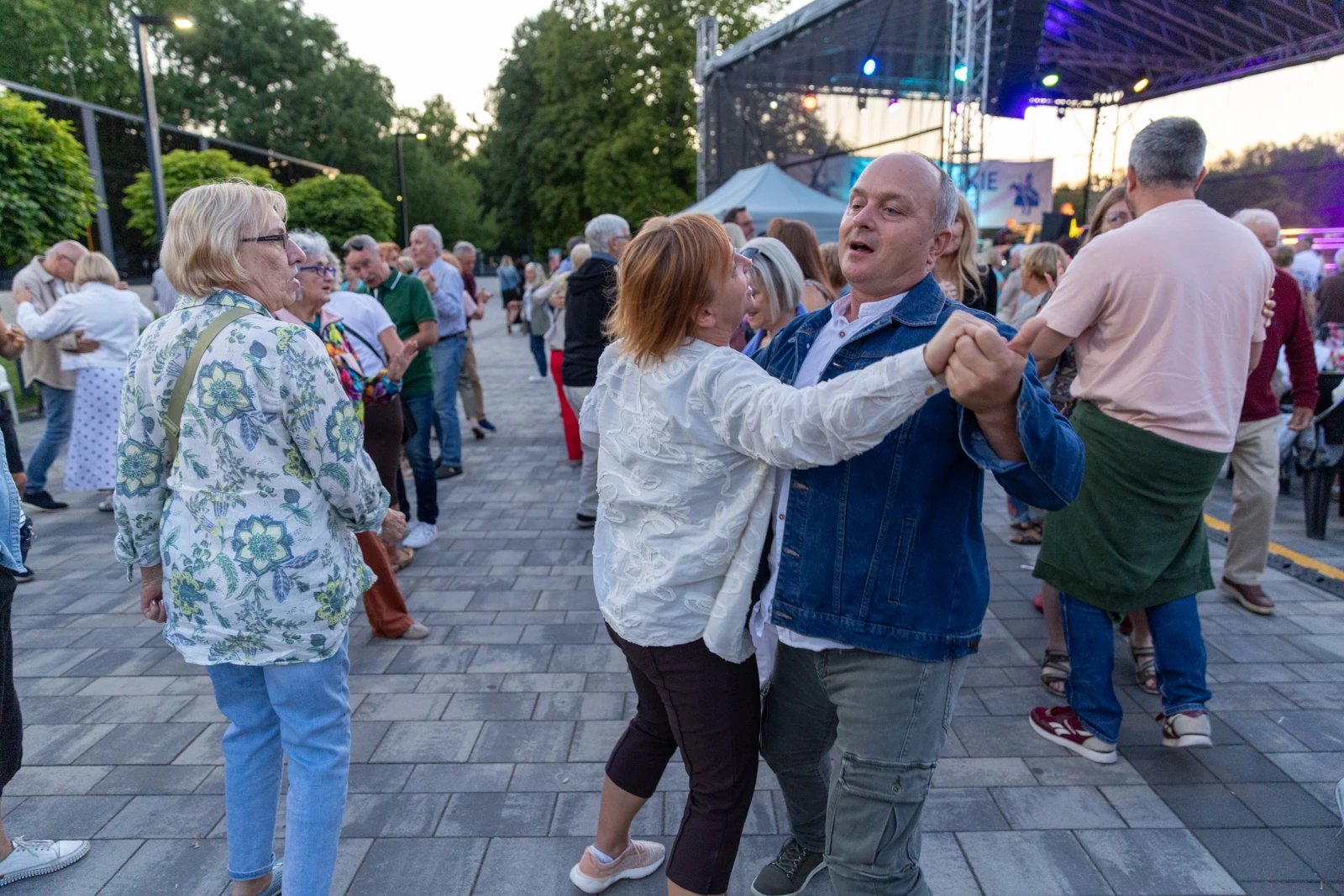 Ludzie tańczą na otwartej przestrzeni podczas wydarzenia kulturalnego.  Autor: Bogusław Świerzowski