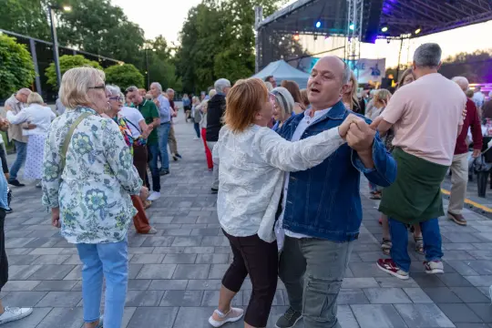 Ludzie tańczą na otwartej przestrzeni podczas wydarzenia kulturalnego.