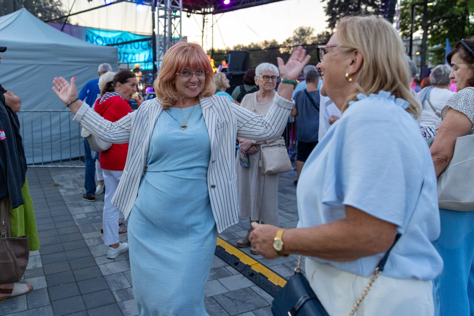 Kobieta w jasnej sukience tańczy na festiwalu, wokół niej tłum ludzi.  Autor: Bogusław Świerzowski