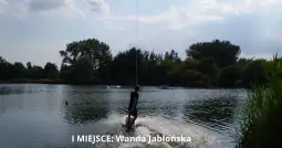 Kobieta na desce wodnej podczas zawodów na jeziorze.