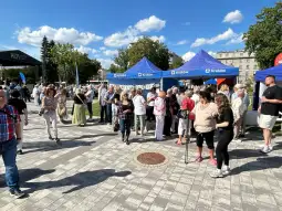 Tłum ludzi na wydarzeniu plenerowym z namiotami w Krakowie.