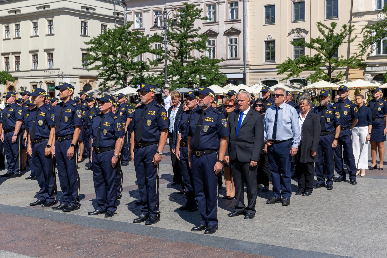 Grupa policjantów i urzędników podczas ceremonii na placu.  Autor: Bogusław Świerzowski