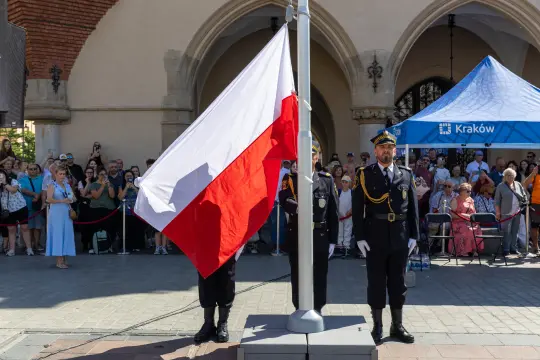 Ceremonia podnoszenia flagi Polski z udziałem strażników i zgromadzonej publiczności.