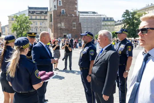 Spotkanie przedstawicieli władz z policją na placu w mieście.