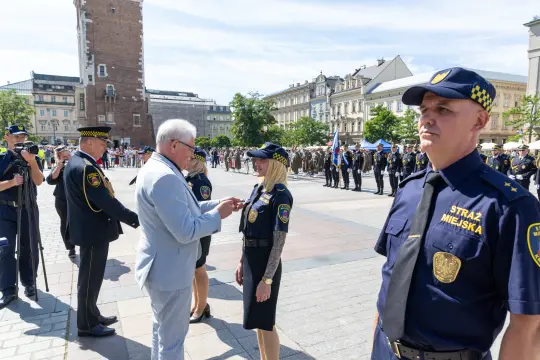 Ceremonia wręczenia odznaczeń strażnikom miejskim na placu w mieście.