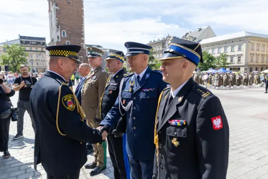 Ceremonia wojskowa z przedstawicielami różnych służb mundurowych w trakcie powitania.