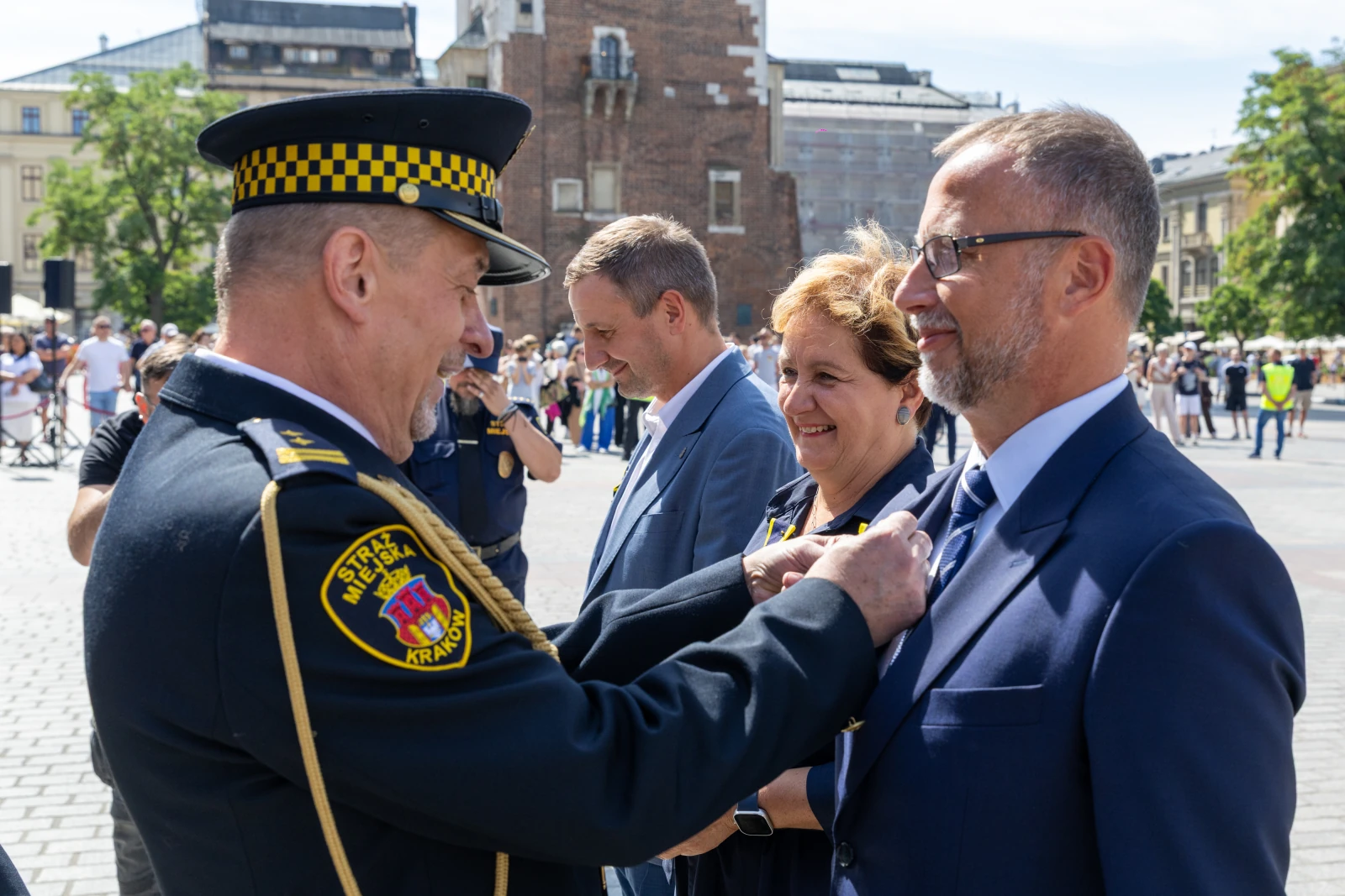 Ceremonia wręczenia odznaczeń w Krakowie, uśmiechnięci uczestnicy w formalnych strojach.  Autor: Bogusław Świerzowski