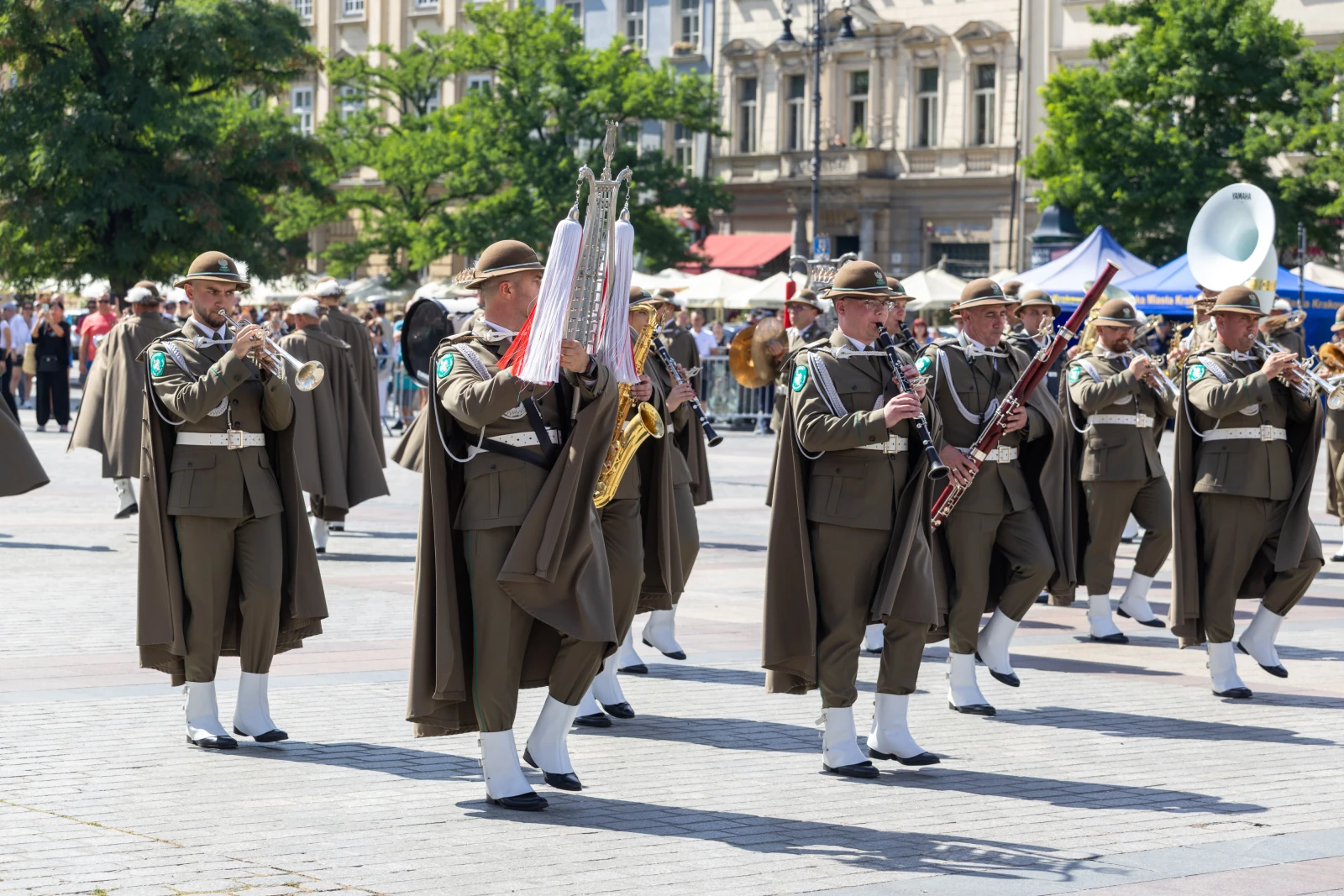 Muzycy w mundurach grający na instrumentach podczas parady na ulicy.  Autor: Bogusław Świerzowski