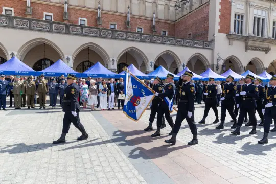 Parada z udziałem strażaków i przedstawicieli służb mundurowych na rynku w Krakowie.