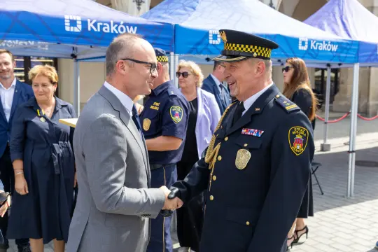 Uroczystość wręczenia odznaczeń w Krakowie, uściski dłoni między przedstawicielami służb.