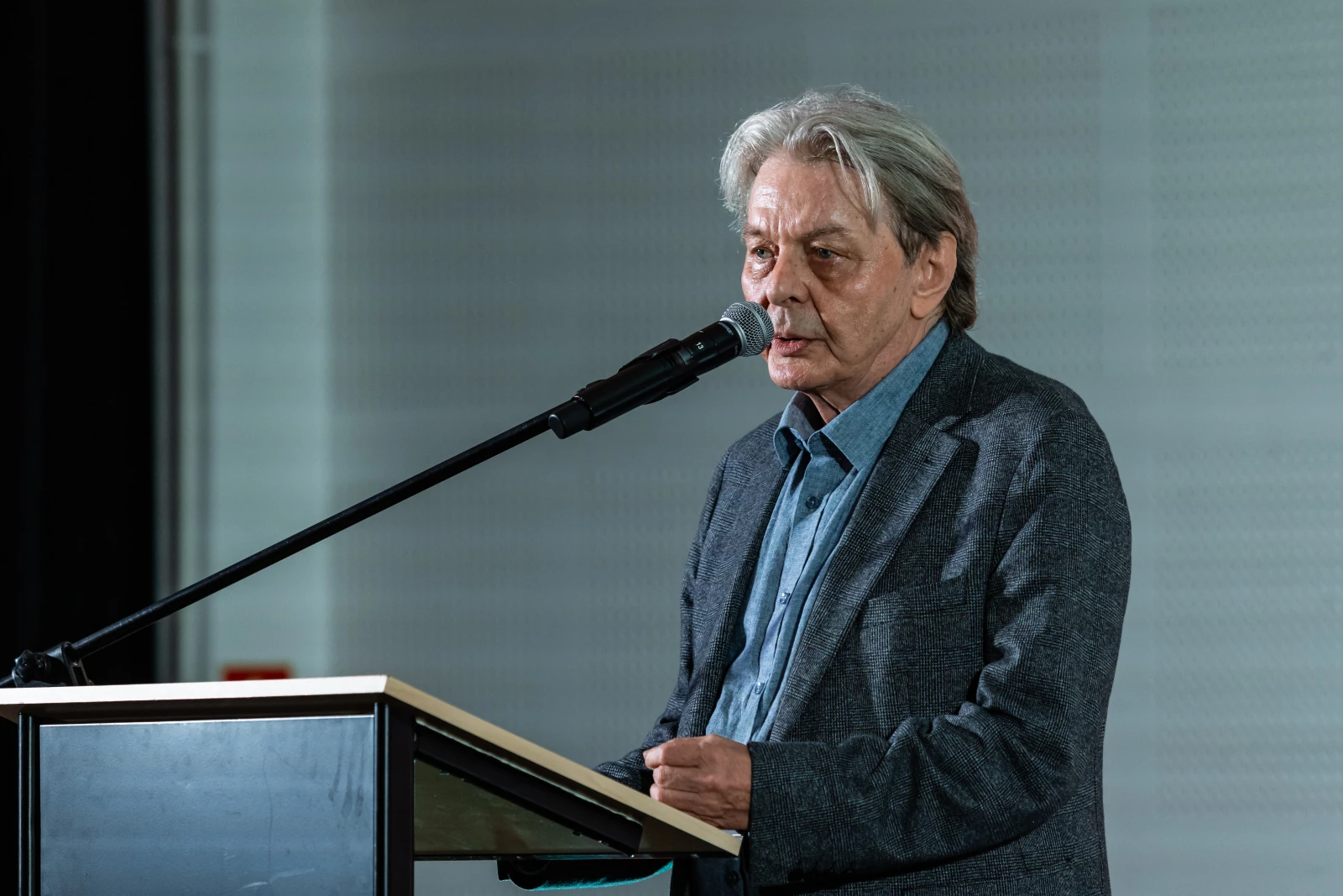 Mężczyzna w szarym garniturze przemawia do mikrofonu.  Autor: Bogusław Świerzowski