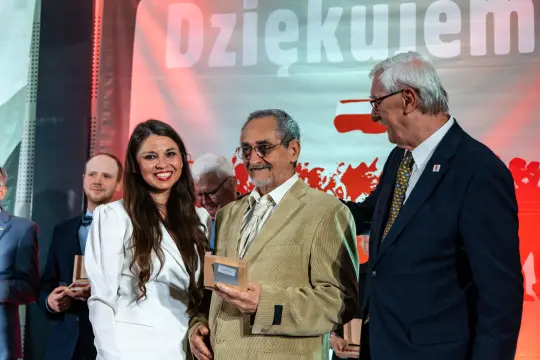 Uroczystość wręczenia nagród, uśmiechnięci laureaci i organizatorzy.