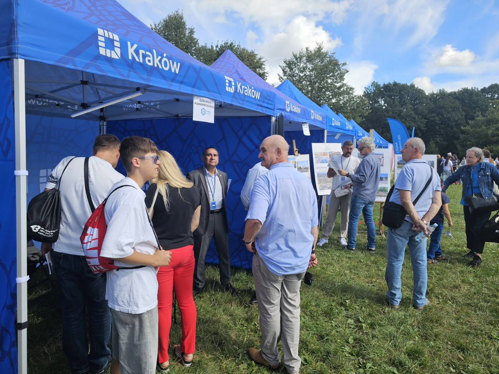 Ludzie rozmawiają przy stoiskach promocyjnych w Krakowie.  Autor: Bogusław Świerzowski