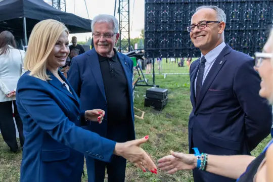 Spotkanie czterech osób, w tym dwóch mężczyzn i dwóch kobiet, w formalnych strojach.