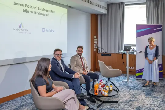 Panel dyskusyjny z uczestnikami i prezentacją na temat biznesu w Krakowie.