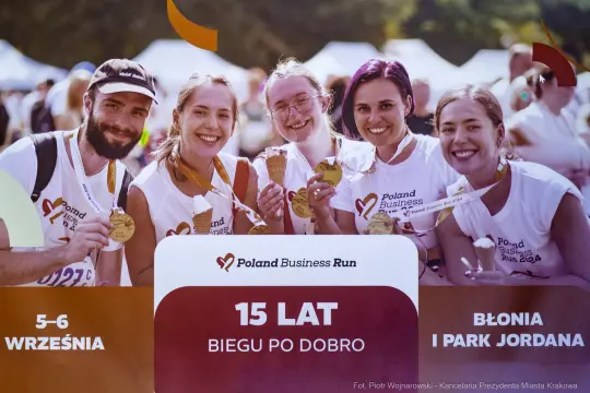 Grupa biegaczy z medalami, świętujących 15-lecie Poland Business Run.