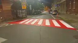 Pasy dla pieszych pomalowane na czerwono na ulicy w mieście.
