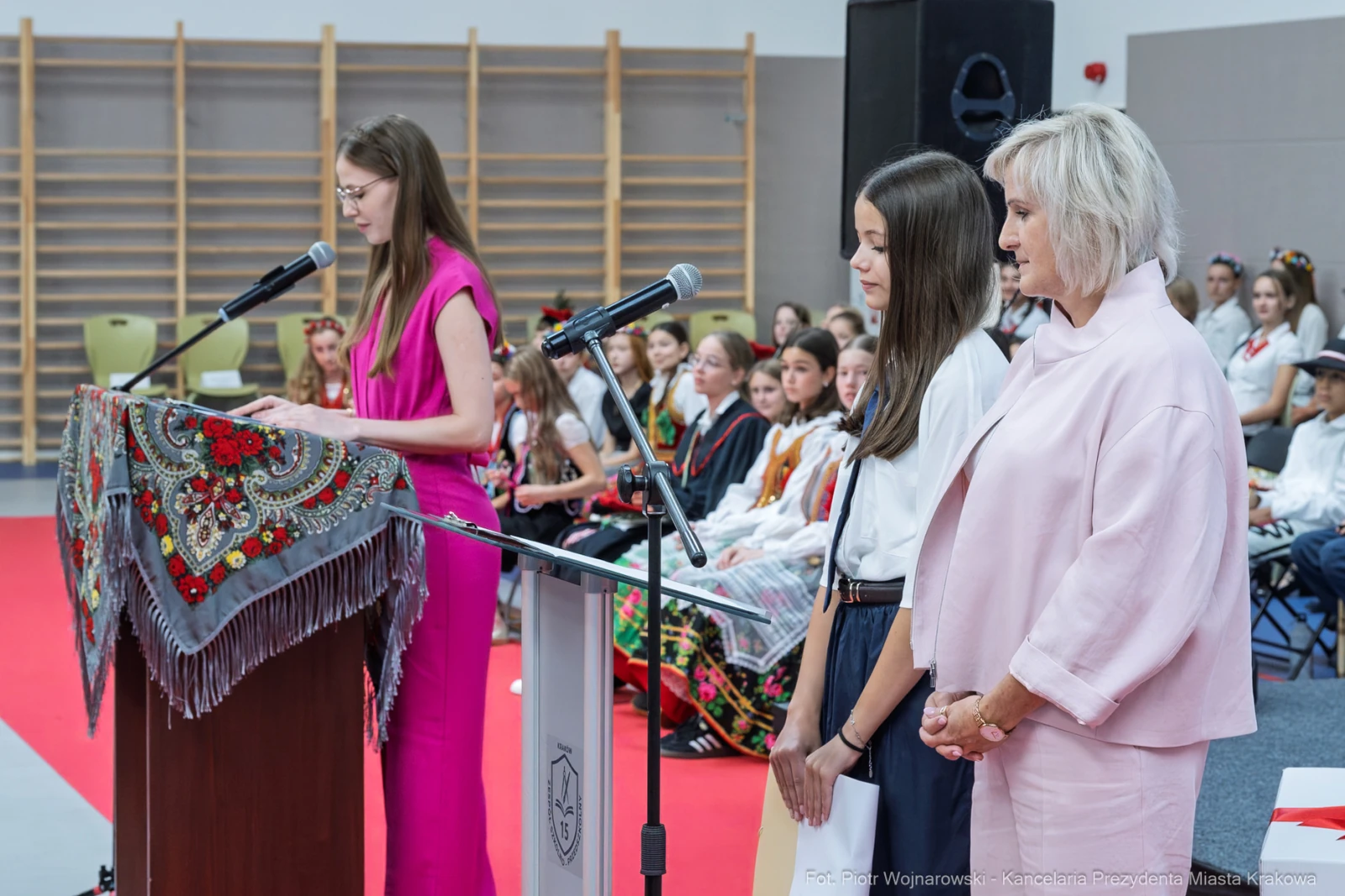 Ceremonia z przemówieniami, uczestnicy w tradycyjnych strojach, dekoracje na stole.  Autor: Piotr Wojnarowski