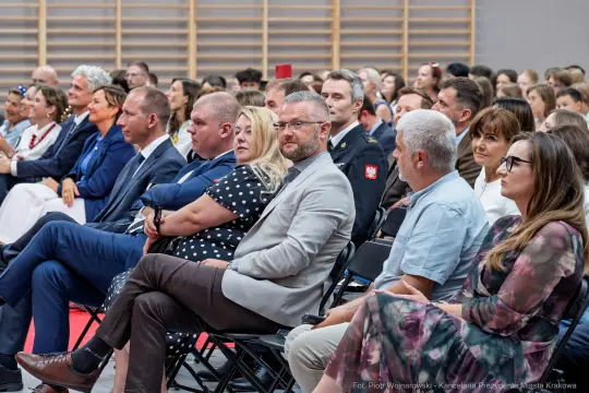 Grupa ludzi siedzących na widowni podczas wydarzenia.