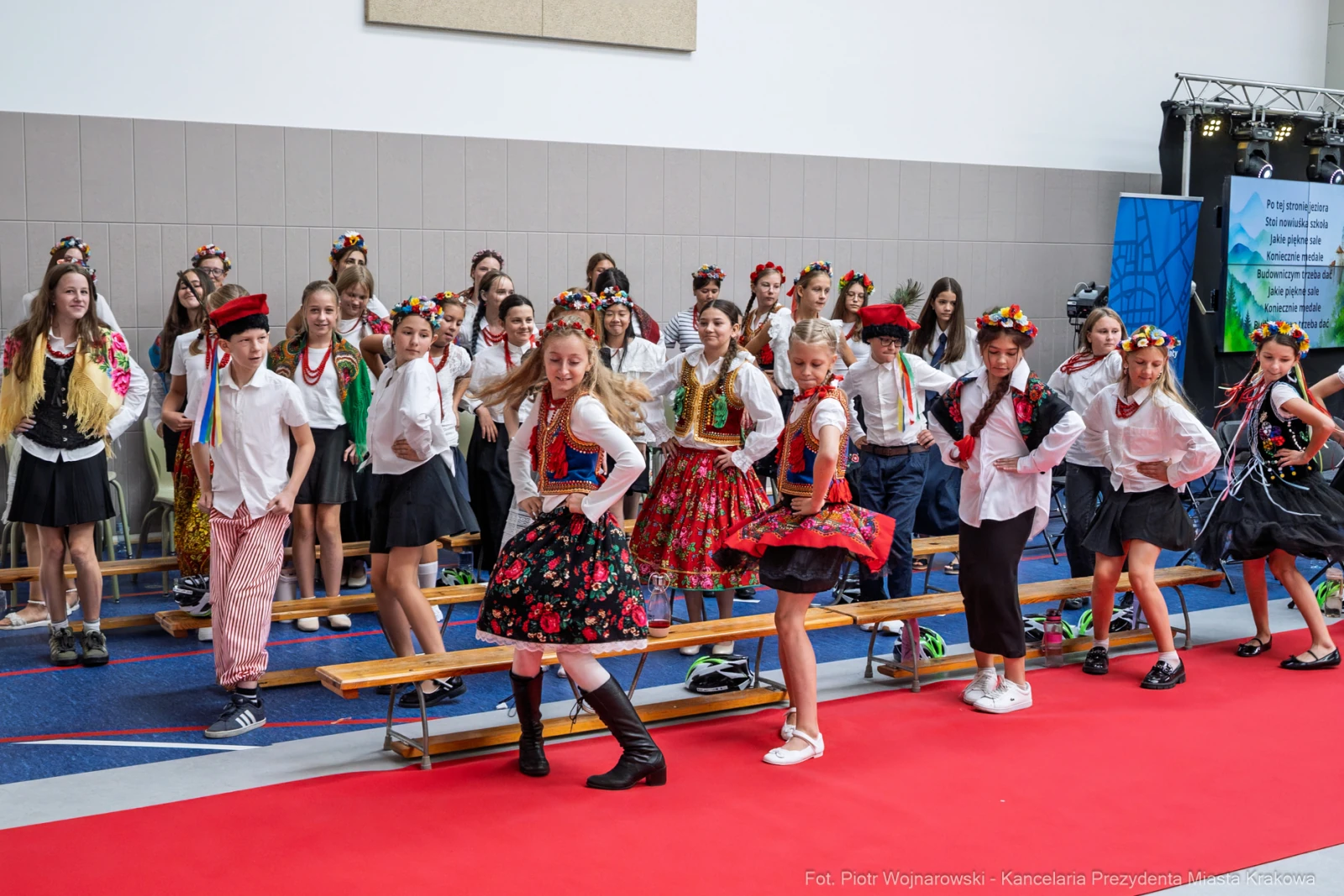 Grupa dzieci w tradycyjnych strojach ludowych tańcząca na scenie.  Autor: Piotr Wojnarowski