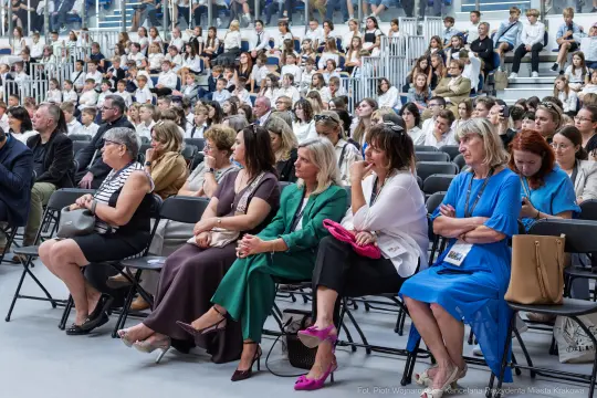 Grupa ludzi siedzących na widowni podczas wydarzenia.