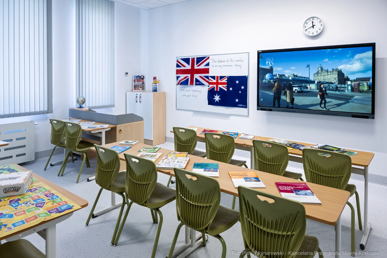 Klasa szkolna z biurkami, tablicą, telewizorem i flagami Australii oraz Wielkiej Brytanii.  Autor: Piotr Wojnarowski