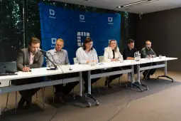 Konferencja prasowa z sześcioma osobami siedzącymi przy stole.