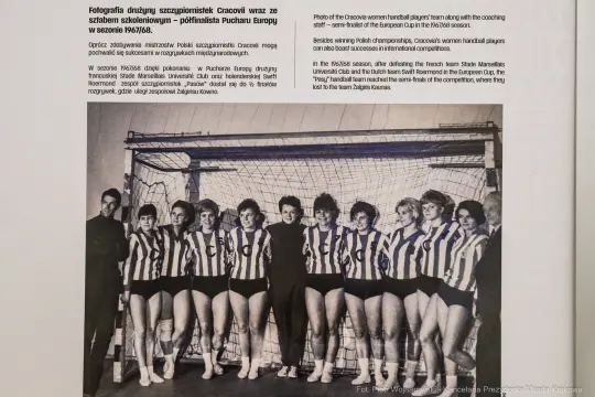Zespół szczypiornistek Cracovii w strojach sportowych, stojących przed bramką.