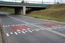 Przejazd z oznaczeniami drogowymi pod wiaduktem.