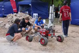 Zespół pracujący nad robotem marsjańskim w terenie.