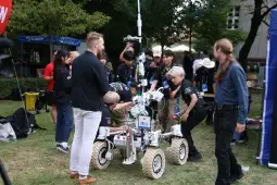 Robot marsjański w trakcie testów, otoczony przez grupę ludzi.