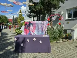 Stół z dekoracjami, tłem z wizerunkiem kobiety i ozdobami w stylu azjatyckim.