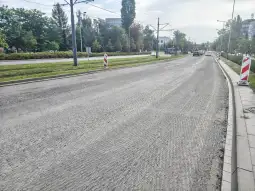 Pusta ulica z oznakowaniem drogowym i świeżo ułożoną nawierzchnią.