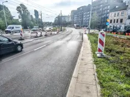 Droga z robotami drogowymi, znaki ostrzegawcze i samochody w ruchu.