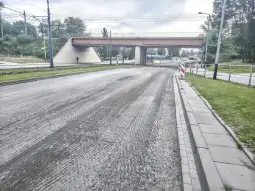 Droga z widokiem na wiadukt, z oznaczeniami robót drogowych.
