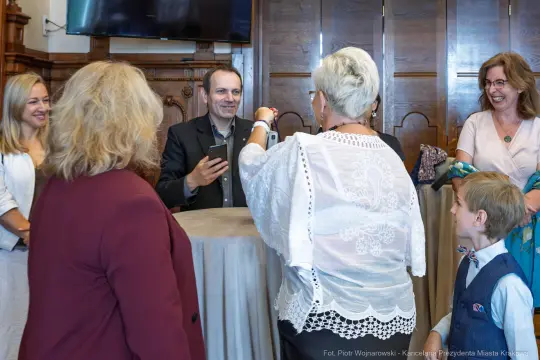 Spotkanie grupy ludzi przy stole, rozmowy i interakcje.