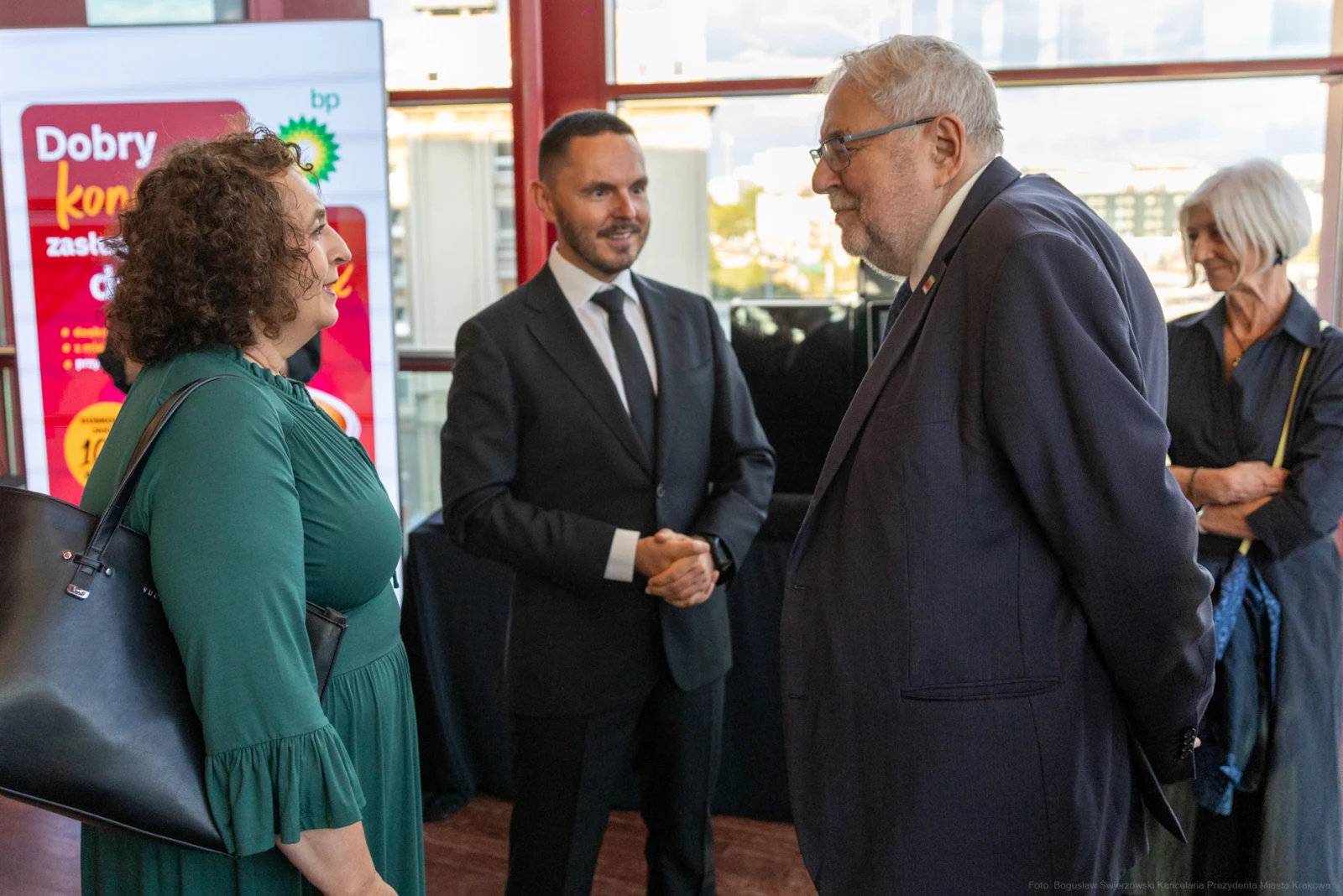 Spotkanie kilku osób w eleganckim otoczeniu, rozmowy i interakcje towarzyskie.  Autor: Bogusław Świerzowski