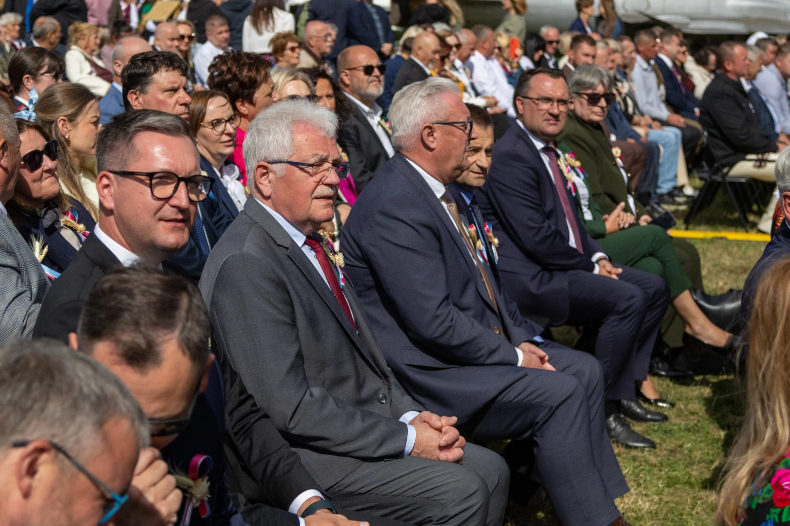 Grupa ludzi siedzących na uroczystości, wśród nich mężczyźni w garniturach z odznaczeniami.  Autor: Bogusław Świerzowski