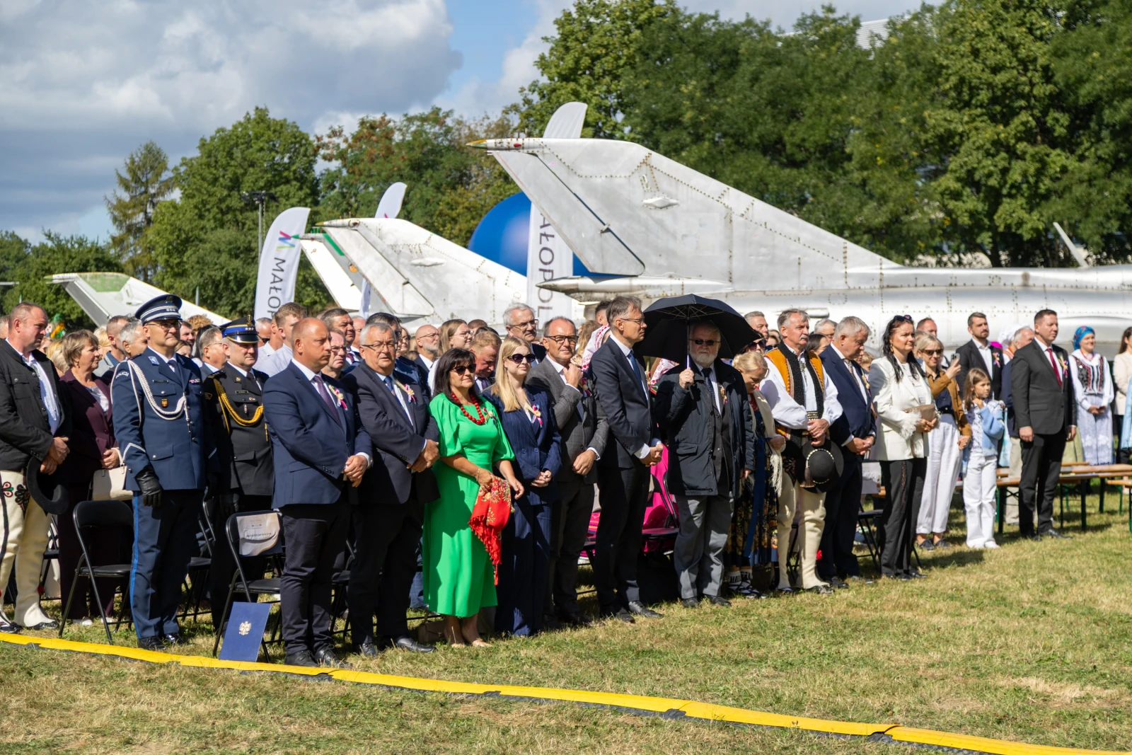 Uroczystość z udziałem wielu osób w mundurach i eleganckich strojach, w tle samoloty.  Autor: Bogusław Świerzowski