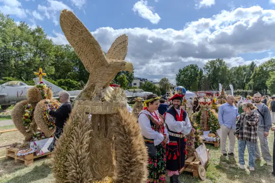 Tradycyjne wieńce dożynkowe z orłem, ludowe stroje, festyn z uczestnikami i widownią.