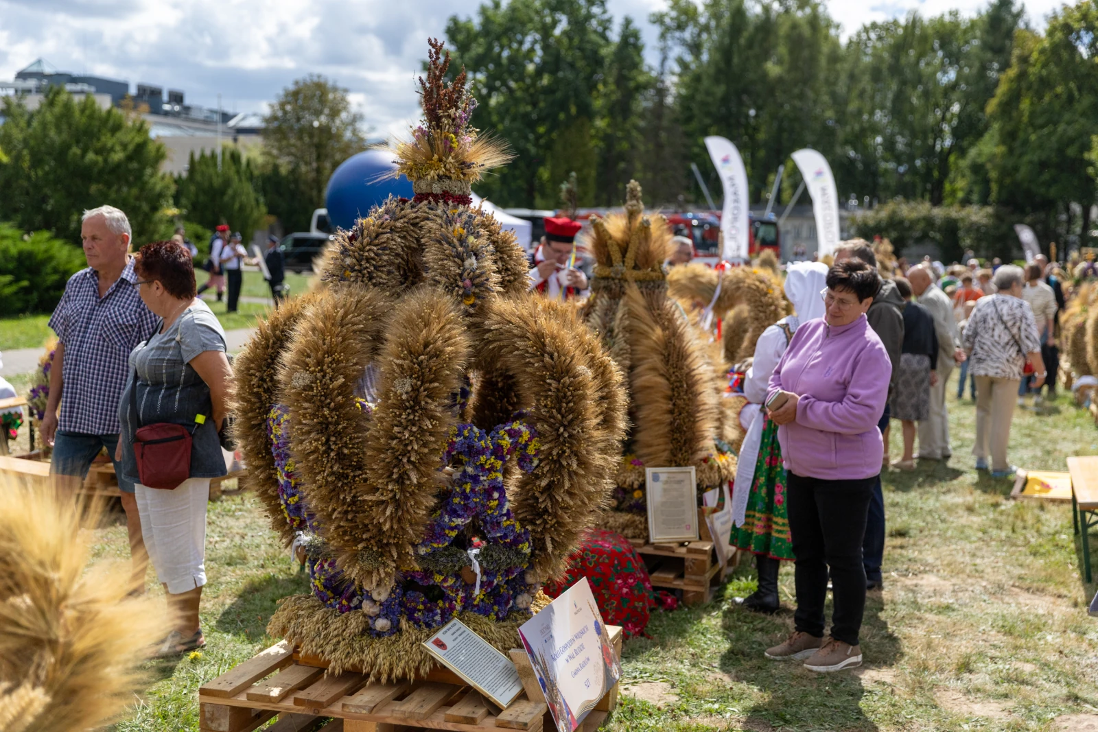 Kwiatowe kompozycje z ziół i zbóż na festiwalu, ludzie w tradycyjnych strojach.  Autor: Bogusław Świerzowski
