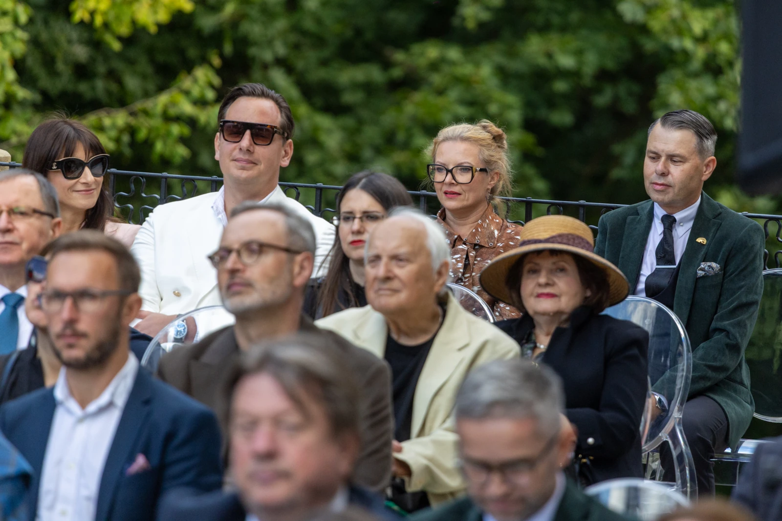 Grupa ludzi w eleganckich strojach, siedzących na wydarzeniu na świeżym powietrzu.  Autor: Bogusław Świerzowski