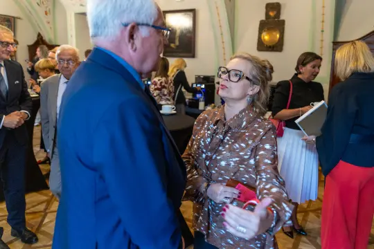 Spotkanie ludzi w eleganckim wnętrzu, rozmowy i interakcje towarzyskie.