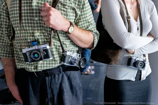 Dwie osoby z aparatami fotograficznymi zawieszonymi na szyi.