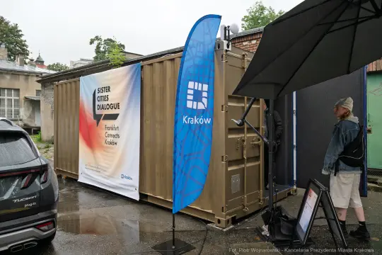 Kontener z banerem promującym dialog miast partnerskich Krakowa i Frankfurtu.