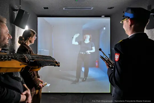 Interaktywna instalacja artystyczna z hologramem i uczestnikami.