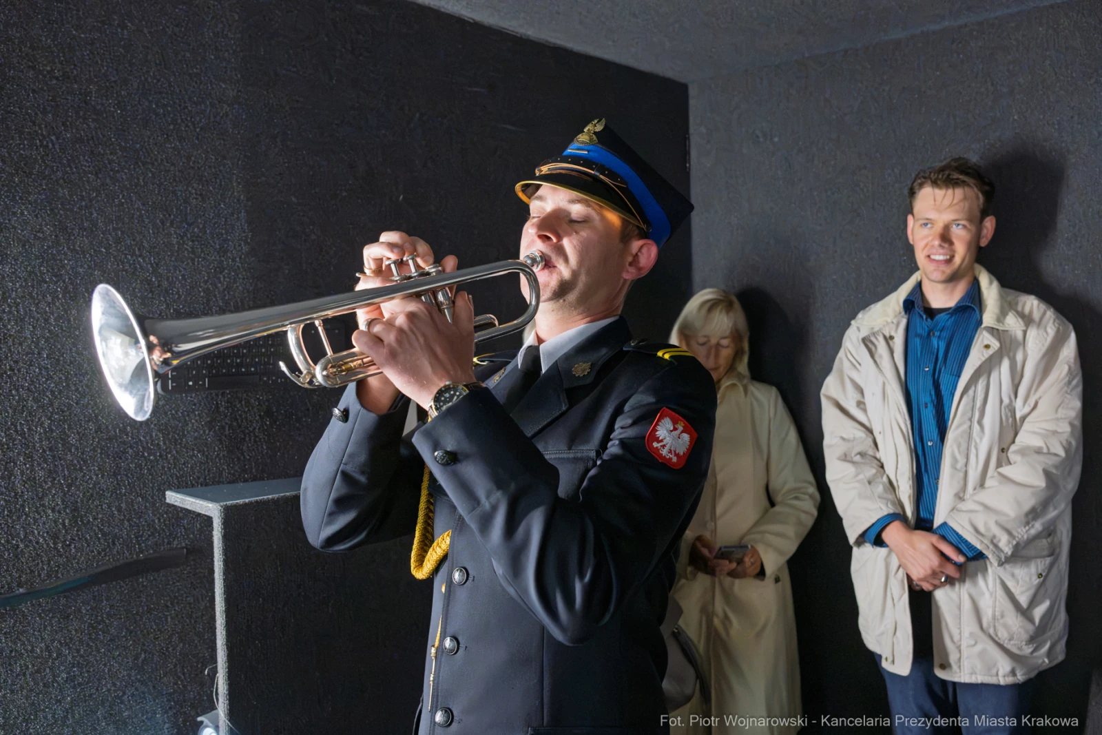 Mężczyzna w mundurze gra na trąbce, obok dwie osoby słuchają.  Autor: Piotr Wojnarowski