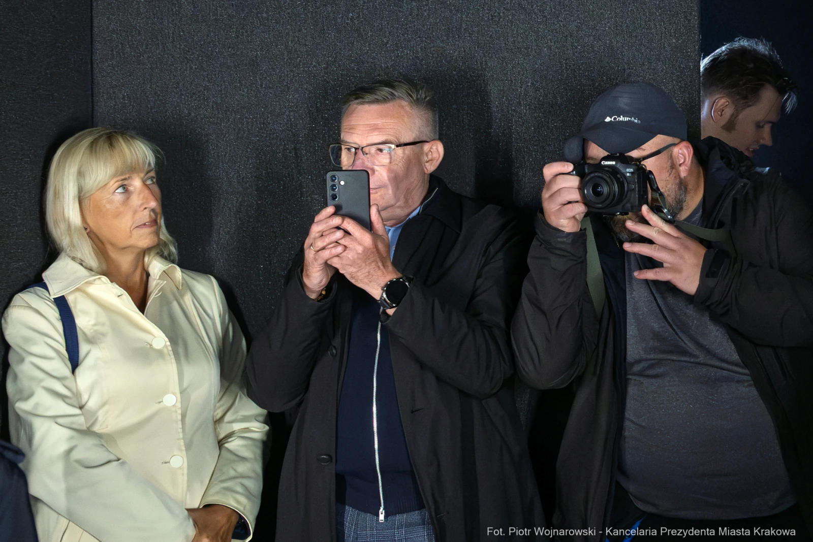 Grupa osób z telefonami, jedna z nich robi zdjęcie, druga obserwuje.  Autor: Piotr Wojnarowski