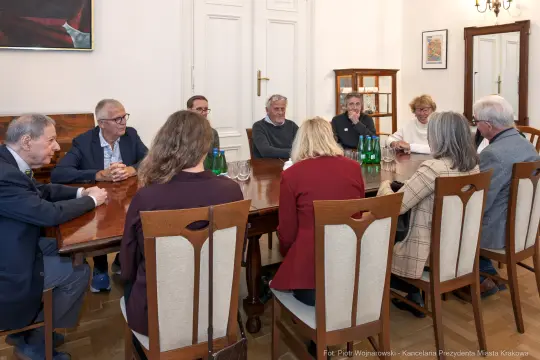 Spotkanie grupy ludzi przy stole w sali konferencyjnej.