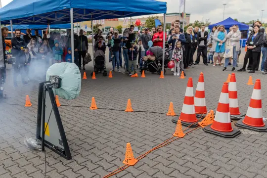 Demonstracja eksperymentu z dymem i przeszkodami, zebrana publiczność.
